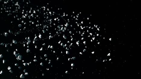 animated stone particles on dark background, simulation of stones and small rocks moving slowly under sunlight in asteroid belt, cosmic derbies concept