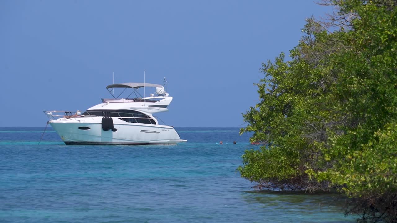 barco anclado en las islas rosario, colombia, cielo azul soleado y aguas tranquilas del océano, escena de paraíso tropical