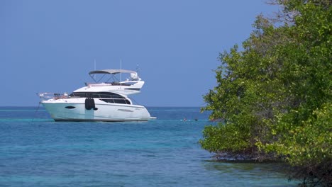 Boat-anchored-off-Rosario-Islands,-Colombia,-sunny-blue-skies-and-tranquil-ocean-waters,-tropical-paradise-scene