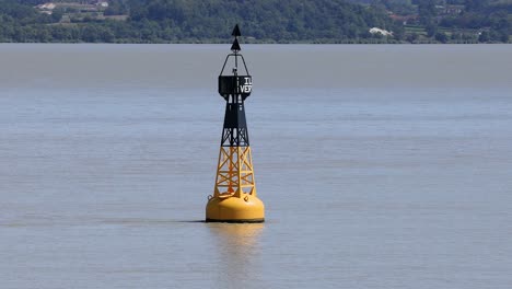 buoy gently sways in calm river waters