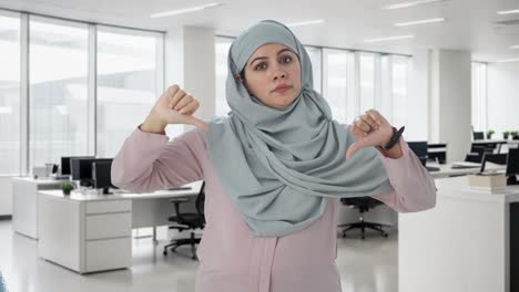 disappointed muslim businesswoman showing thumbs down