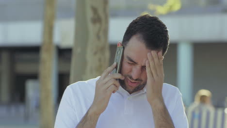 un joven molesto hablando por teléfono.