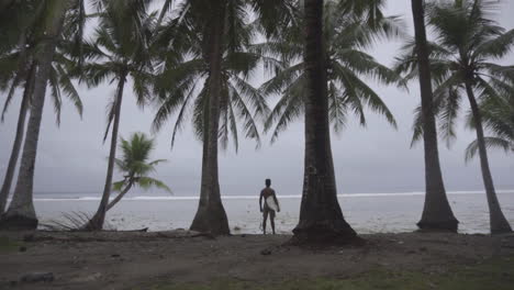 back shot of asian surfer looking at waves