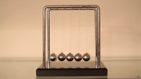 newton's cradle over cream background front view