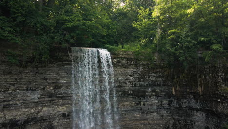 Retroceso-Desde-La-Parte-Superior-De-La-Cascada-De-Cinta-De-Tew-Falls-Con-Acantilado-De-Roca-Sedimentaria-En-Capas