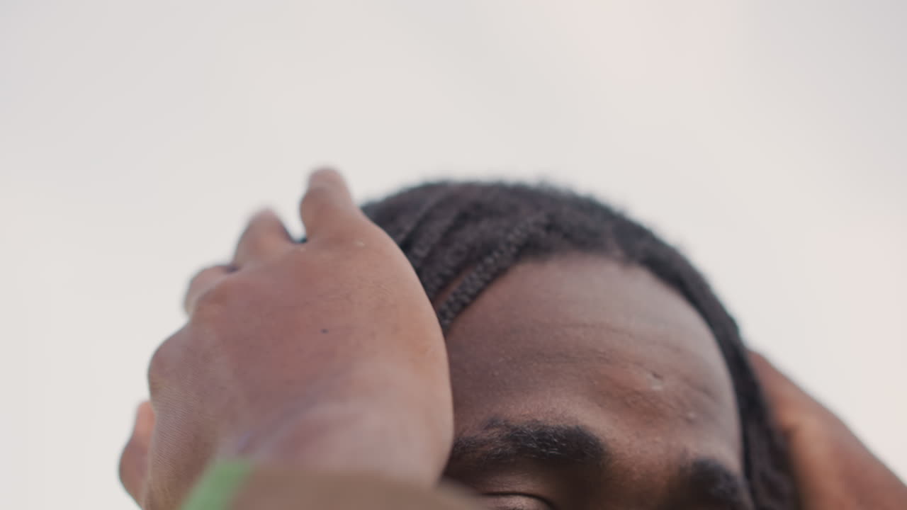 Focused Grooming Routine, Calmly Adjusting Dreadlocks Under Open Sky During Preduty Ritual, Close View Of Recruit Meticulously Arranging Dreadlocks Before Field Assignment Under Clear Sky