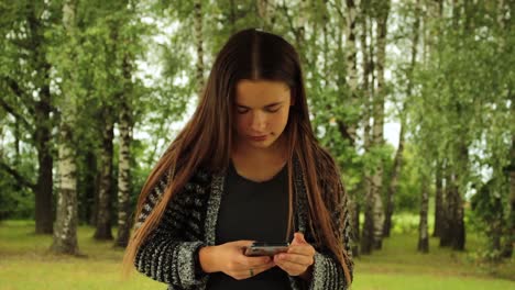 chica en su teléfono en la naturaleza