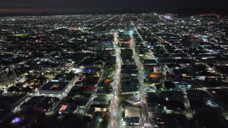 recorrido aéreo con drones por la noche en una ciudad llena de luces y autos a alta velocidad en 4k