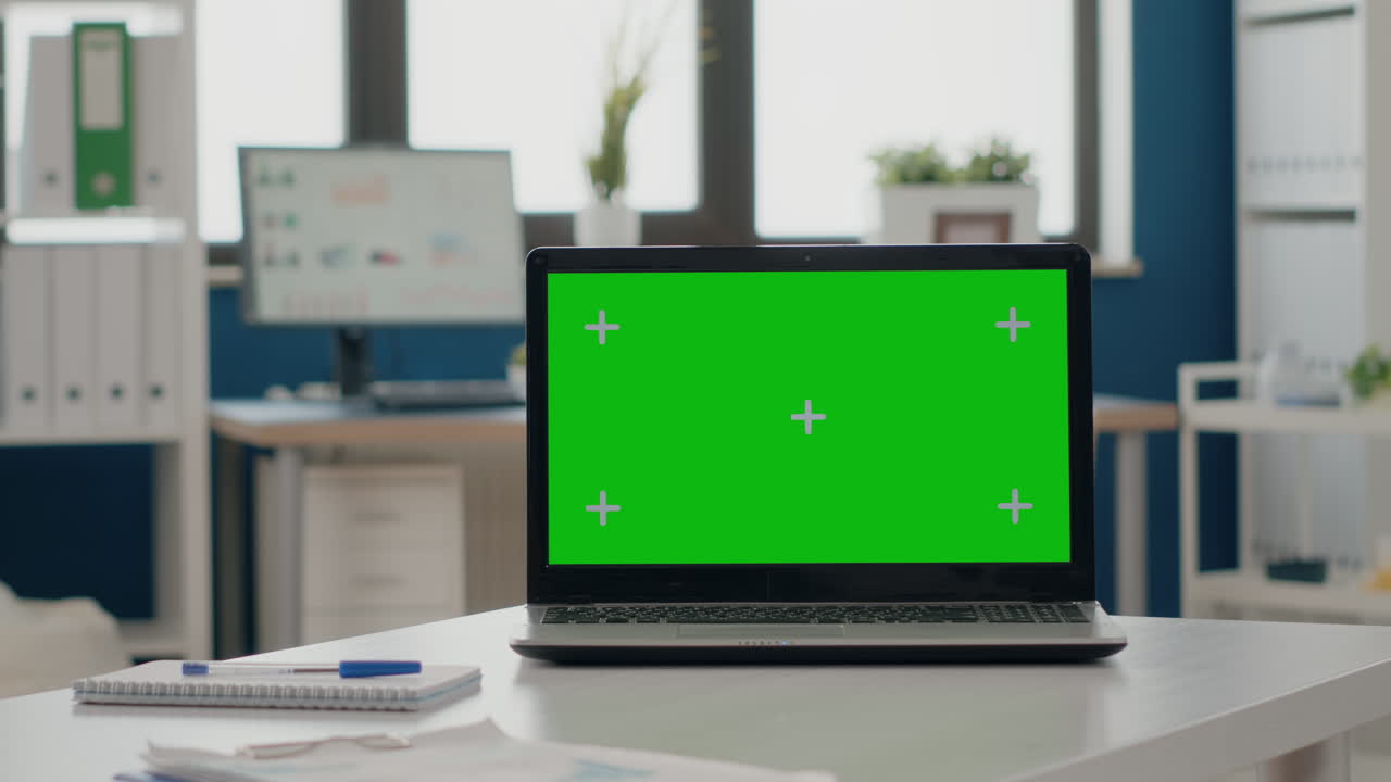 Close up of laptop with green screen in empty office