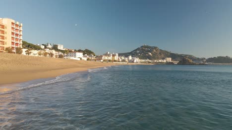 aerial video of blanes girona drone, mediterranean beach without people crystal clear turquoise water city of costa brava european tourism