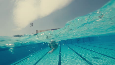 mujer nadar la parte delantera arrastrarse en una piscina olímpica día soleado cámara lenta