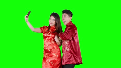 asian couple taking selfie photo in studio