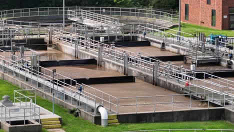sewage plant and wastewater treatment in america. sunny day in suburb of town. sedimentation tanks and pool filtering dirt. aerial view