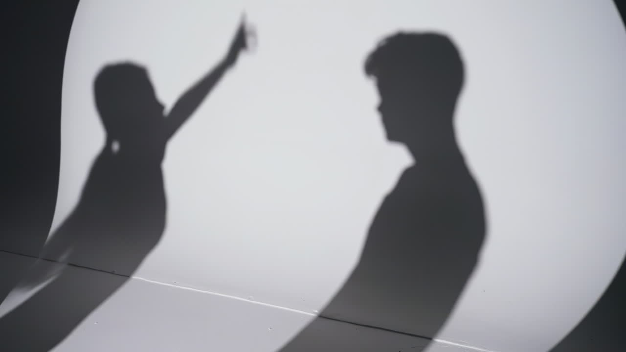 Sylwetka zdenerwowanej pary – młodego mężczyzny i kobiety, kłócących się, spierających, rozwodzących się. Przemoc domowa i problemy w związku. Sfrustrowana żona rzucająca papierami podczas kłótni z mężem.