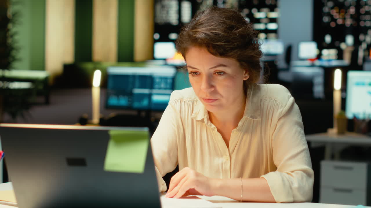 Vertical Video Corporate employee focused on writing a detailed report under a desk lamp