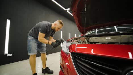 trabajador pulir un coche rojo. detalles de automóviles - los hombres están usando maquinaria pulidores de automóviles mantenimiento para eliminar marcas reparación de acuerdo con la superficie de la pintura del coche antes de continuar a recubrir la cerámica