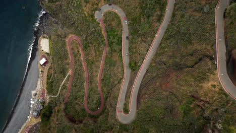 Flying-over-Garajau-Beach-and-Zigzag-Road-to-Cristo-Rei-in-Madeira,-Portugal