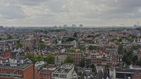 Amsterdam-Netherlands-Aerial-v23-drone-low-level-flyover-the-neighborhoods-of-grachtengordel-west-and-jordaan-with-rows-of-gabled-townhouses,-cinematic-fly-towards-the-skyline---August-2021