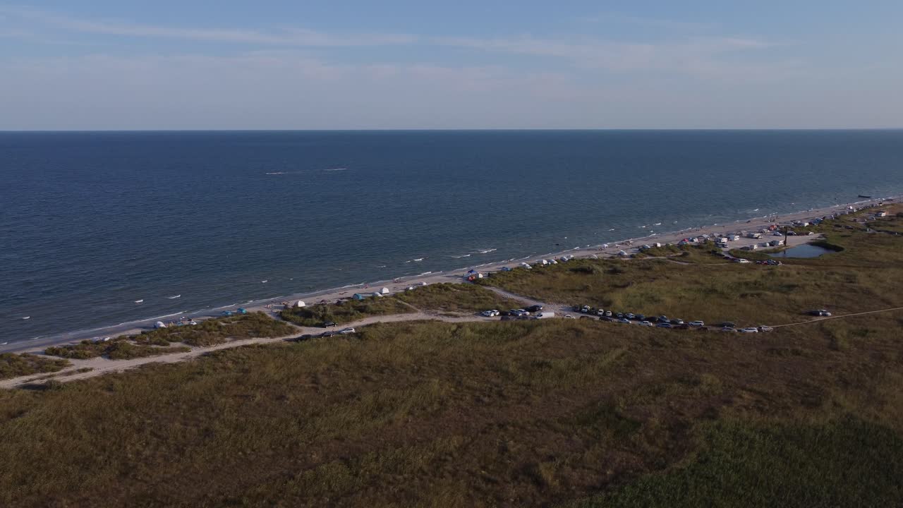 Incantevoli gruppi di persone che campeggiano sulla riva del Mar Nero, su una spiaggia selvaggia con camper e fuoristrada 4x4.
