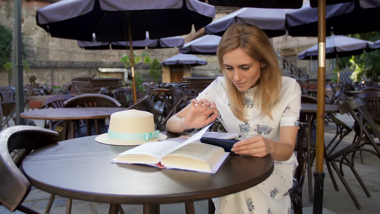 una mujer usando un teléfono inteligente en una cafetería.