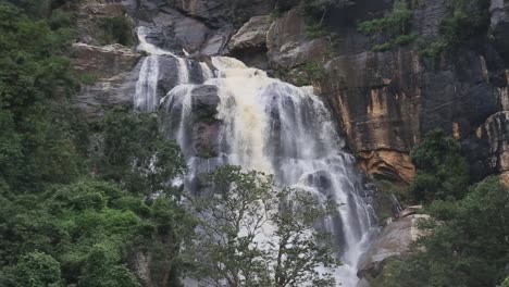 lush jungle waterfall flows strongly down rocks