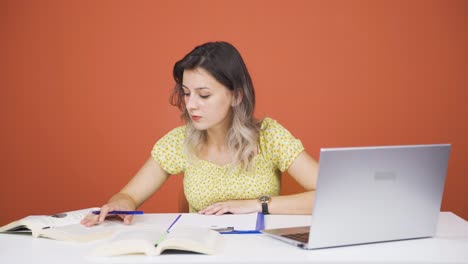 mujer joven concentrada trabajando en una computadora portátil.