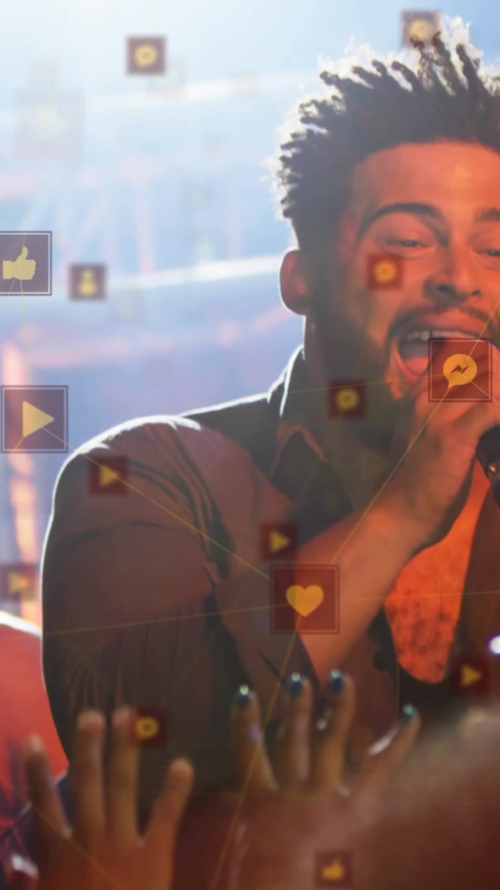 Animasjon av ikoner som svever over en mangfoldig mannlig sanger og musiker på konsert.