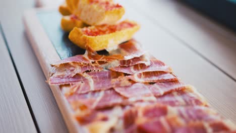 Platter-of-Iberian-ham-and-tomato-bread-in-a-showcooking