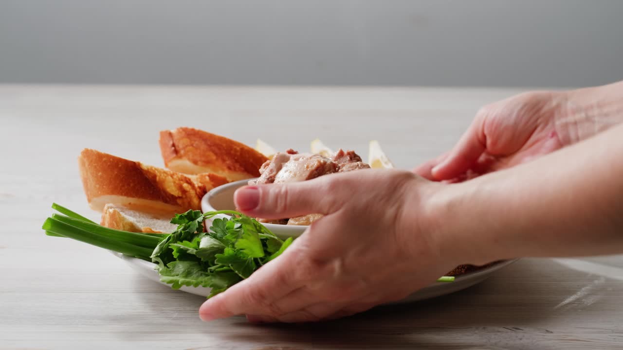 Smoked cod liver in oil in open tin can with fresh greens on wooden table. Seafoods delicacy. High quality 4k footage