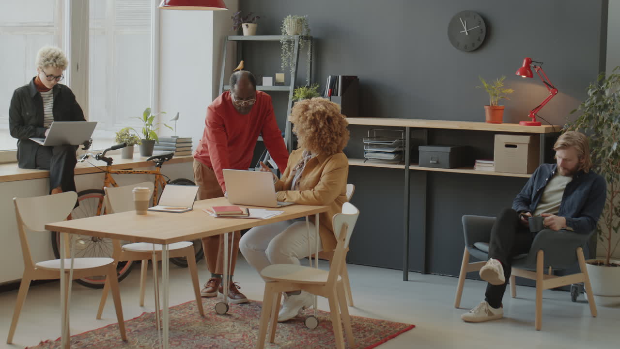 African American Colleagues Using Laptop during Office Workday