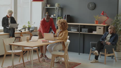 african american colleagues using laptop during office workday