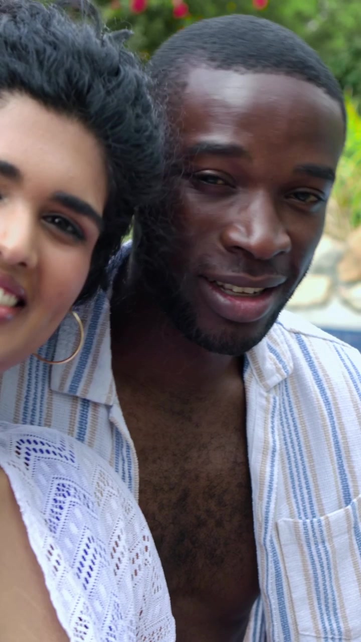 Mulher se inclinando em direção ao homem que entra no enquadramento, trocando sorrisos enquanto corações animados surgem acima das cabeças para marketing.