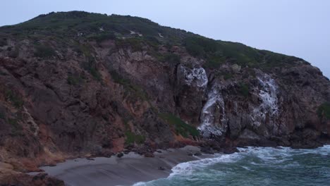 una vista de cerca de los escarpados y rocosos acantilados de malibu, mostrando el paisaje dramático donde la tierra se encuentra con el océano pacífico