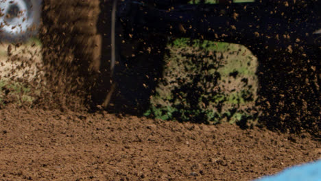 dune buggy sprays dirt in slow motion as it races through a race track