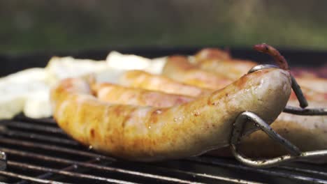 turning thuringian bratwurst a typical german sausage during barbecue