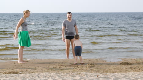 Los-Padres-Y-El-Niño-Jugando-A-La-Pelota-En-La-Playa.