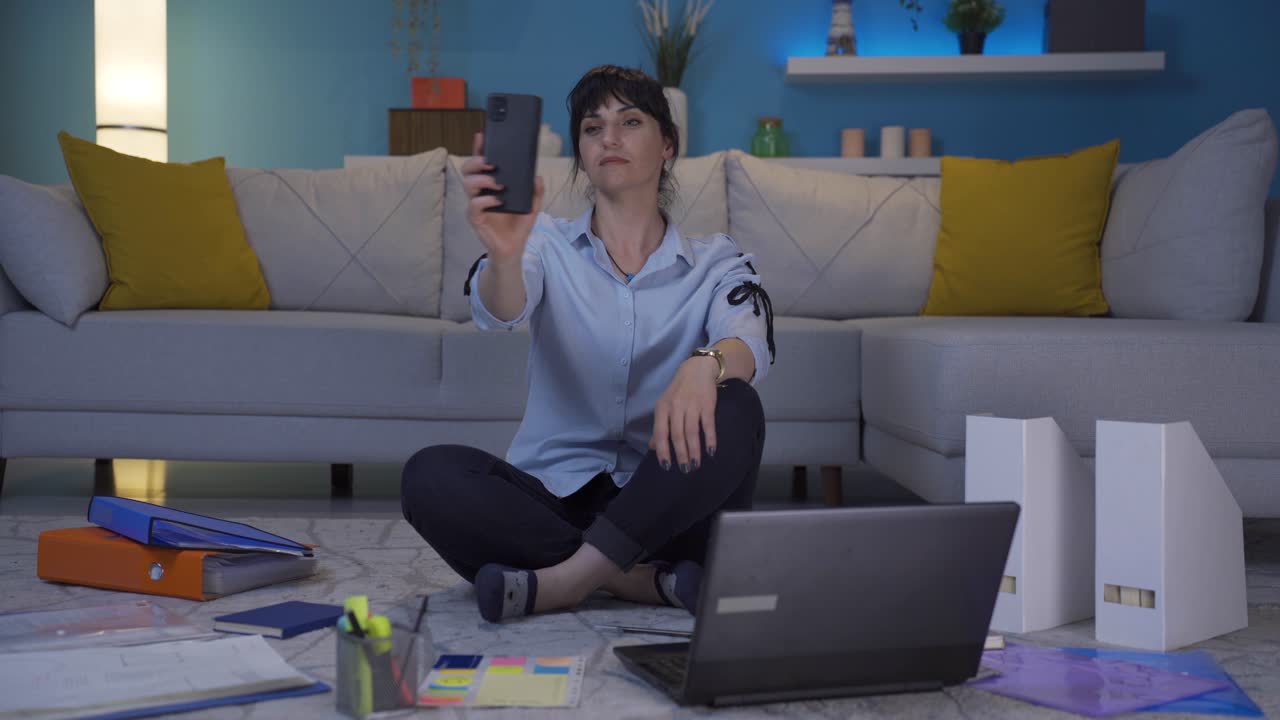 una trabajadora de oficina en casa mirando a la cámara con complacencia.