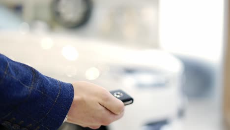 Man-hand-open-the-car-with-car-remote-key-at-car-showroom