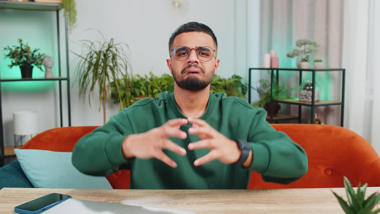 Uomo arabo sconvolto che mostra il pollice in giù disprezza il cattivo lavoro disapprovazione feedback insoddisfatto a casa