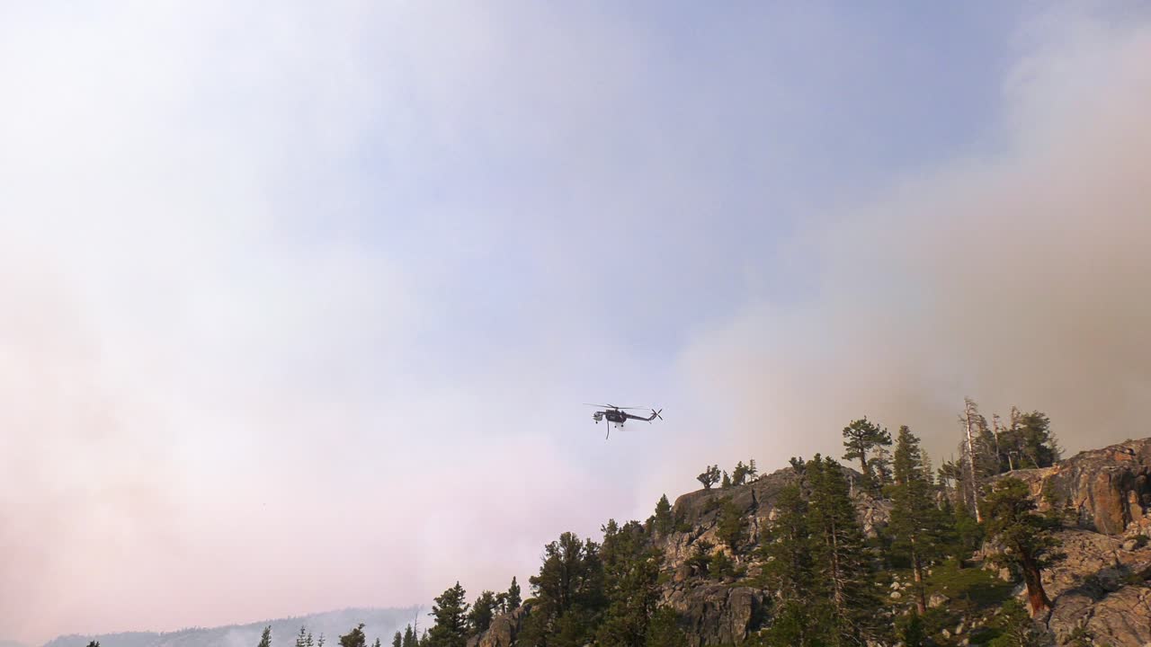 미국 서부에서 물을 떨어뜨리고 산불을 진압하는 소방관 헬리콥터 - 슬로우 모션 보기