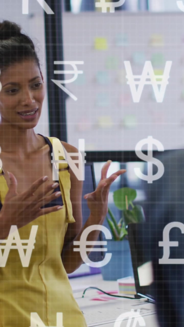 Animation of currency symbols against african american woman talking to diverse colleagues at office