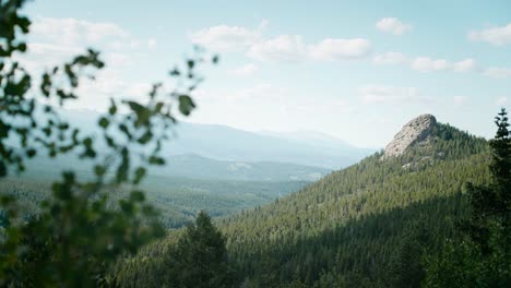 Erleben-Sie-Die-Atemberaubende-Sicht-Auf-Eine-Gewaltige-Bergkulisse,-Während-Die-Kamera-Den-Fokus-Auf-Bäume-Und-Äste-Richtet