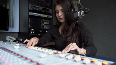 hermosa joven, dj de radio hablando con la audiencia mientras trabaja en mixete