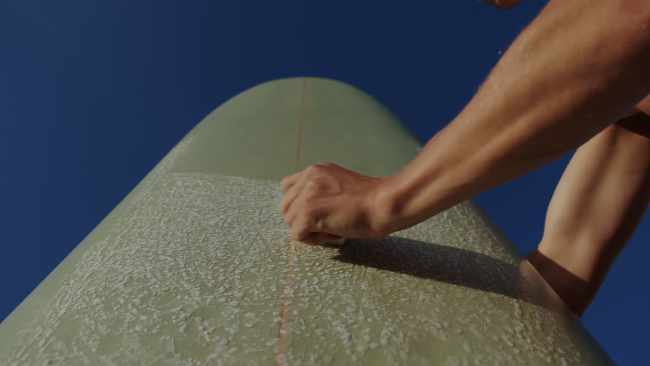 Surfer man walking to the beach at sunset preparing for surfing training and search for waves in Barcelona, spain, water, ocean exercise in sea with board, athletic male holiday or travel in vacation