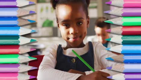 Animation-of-crayons-over-african-american-schoolgirl