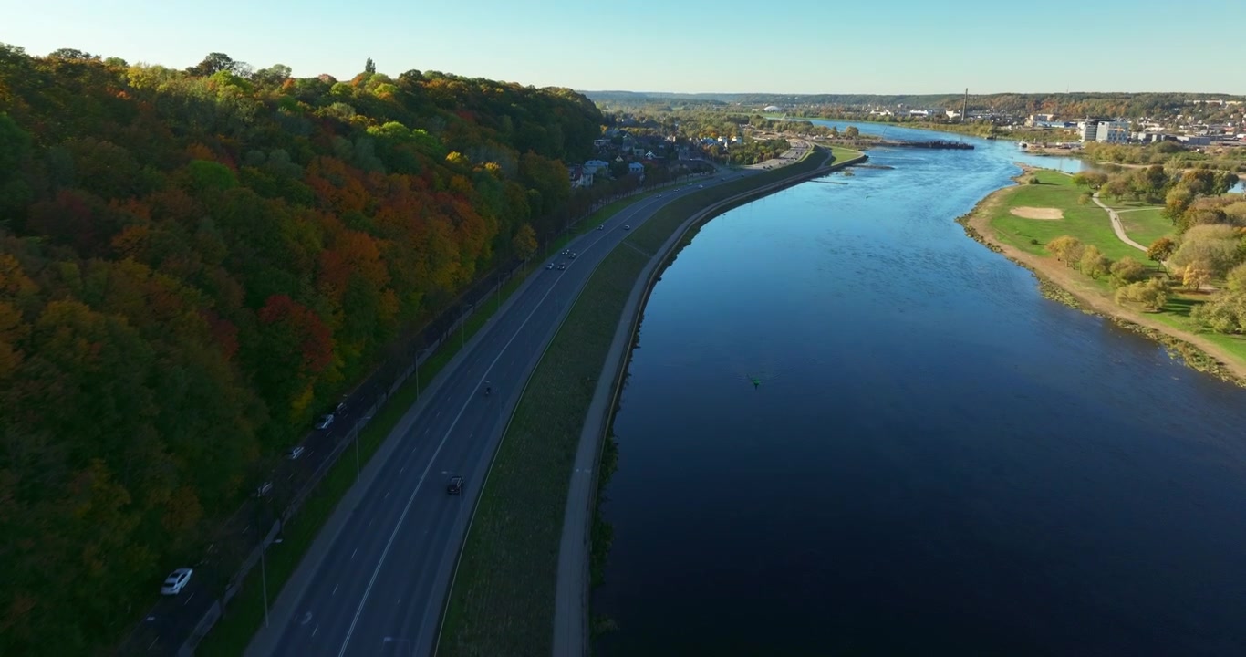 Riprese aeree con telecamera sopra la riva sinistra del fiume Nemunas, situato a Kaunas, Lituania, Europa. Bellissimo paesaggio autunnale con la strada vicino ai fiumi visibile. Filmato ProRes 4K di alta qualità.