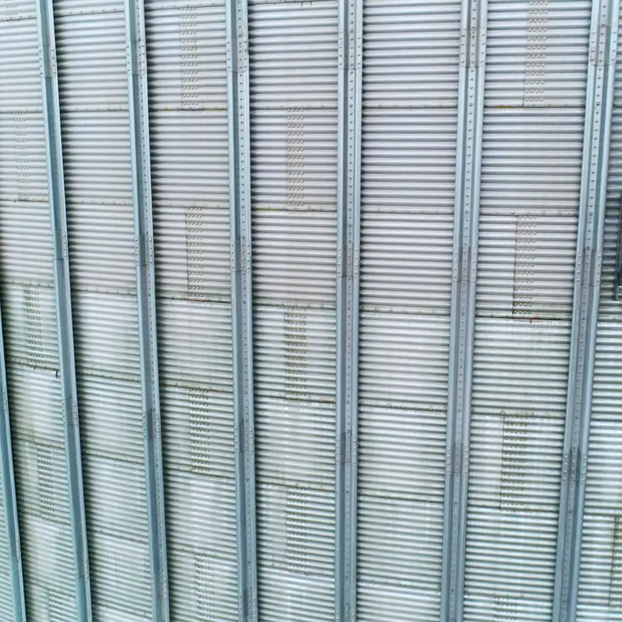 Exterior of two silo tanks in the modern agribusiness plant. Silver metal cover over the tanks for storage and processing crops