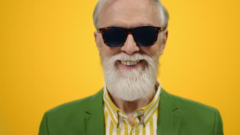 hombre alegre sonriendo a la cámara en el interior. hombre viejo con estilo posando en el estudio.
