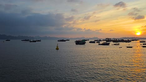 fishing boats on ha long bay at golden hour sunset in quang ninh, vietnam. wide static shot