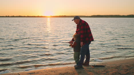 Pescando-En-La-Orilla-Del-Río-O-Del-Lago,-El-Abuelo-Y-El-Nieto-Están-Pescando-Con-Caña-De-Pescar